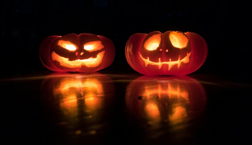 Two carved pumpkins in a black background