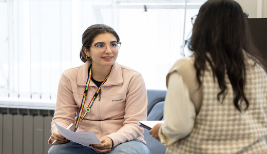 Two students sitting down chatting