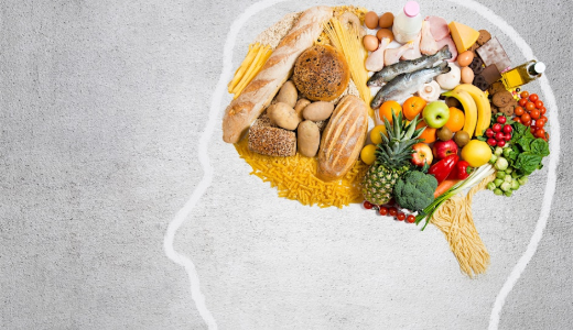 An outline of a human head filled with various foods, including bread, pasta, fruit, vegetables, fish and dairy, arranged to resemble a brain.