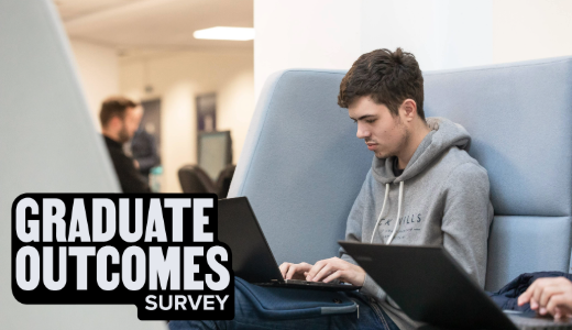 A student seated in a study space using a laptop and tablet, with text reading “Graduate Outcomes Survey”.