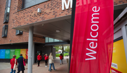 Welcome banner displayed outside a University building during an event.