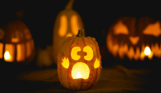 Carved pumpkins illuminated by candlelight during a Halloween display.